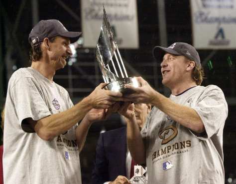 Arizona Diamondbacks pitcher Randy Johnson, left, and Curt Schilling, right, hold the World Series MVP trophy they will share after being named co-receipiants of the World Series Most Valuable Player award after the Diamondbacks beat the New York Yankees 3-2 in Game 7 of the World Series Sunday, Nov. 4, 2001, at Bank One Ballpark in Phoenix. (AP Photo/David J. Phillip)
